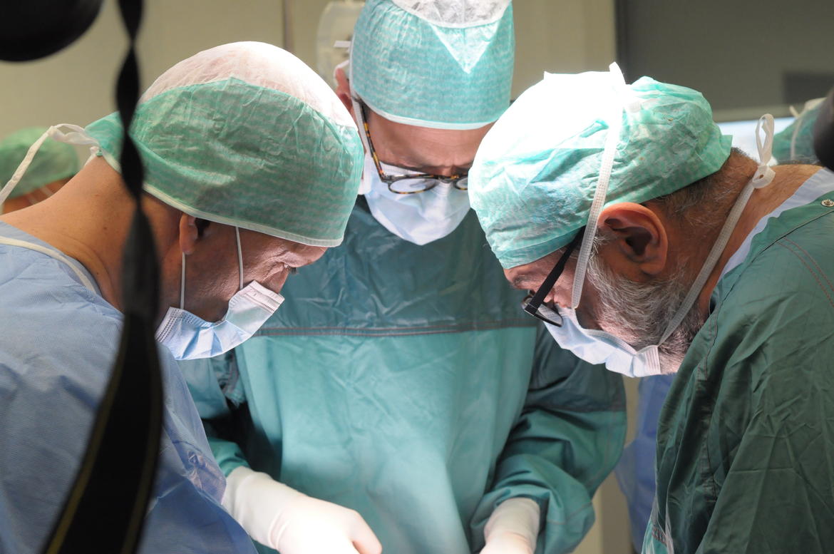 Equipe di medici durante un intervento chirurgico in sala operatoria per ricostruire la parete addominale con muscoli della gamba 